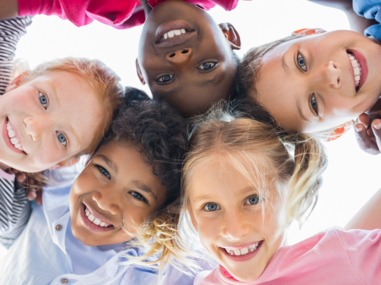 five children smiling in huddle